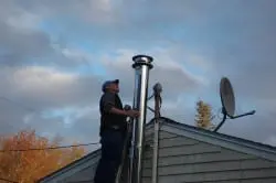 Chimney Sweep Cleveland Ohio Expert Performing Fireplace Cleaning Services on Top of Roof for Fireplace Cleaning and Inspection Near Me